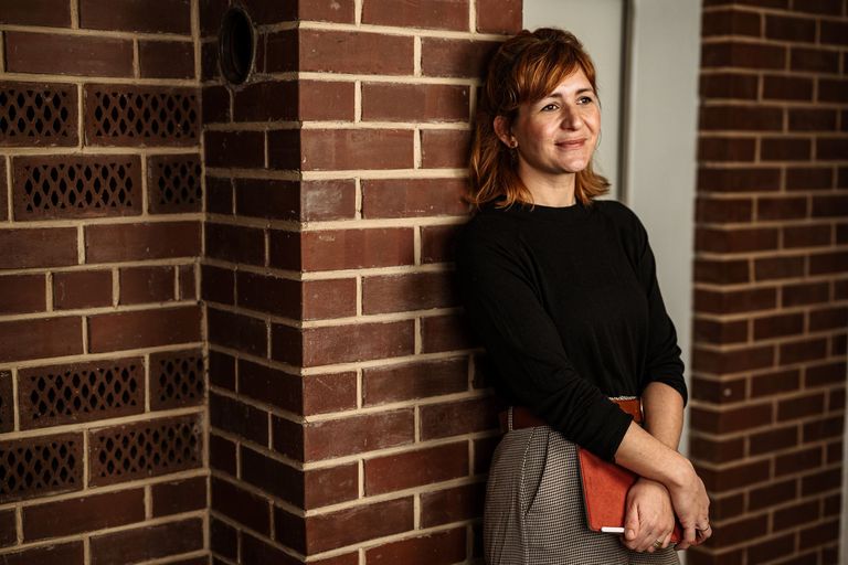 Foto Julia Rosenberg – lehnt stehend an Wand und hält ein Tablet in den Händen