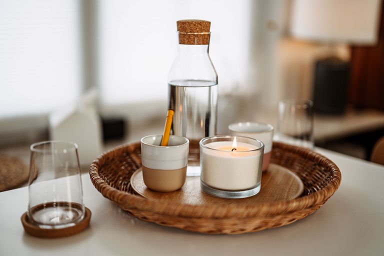Foto des Praxisraums – Ein Tablett mit Kerze, Wasserkaraffe und Gläser auf einem 