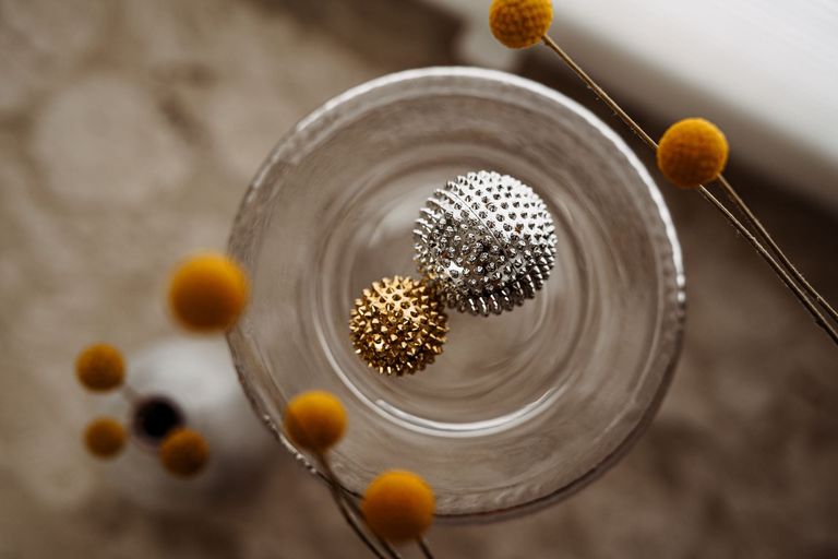 Eine große silberfarbene und eine kleinere goldfarbene Akupressurkugel (Therapiemittel für das Skillstraining bei emotionaler Instabilität)