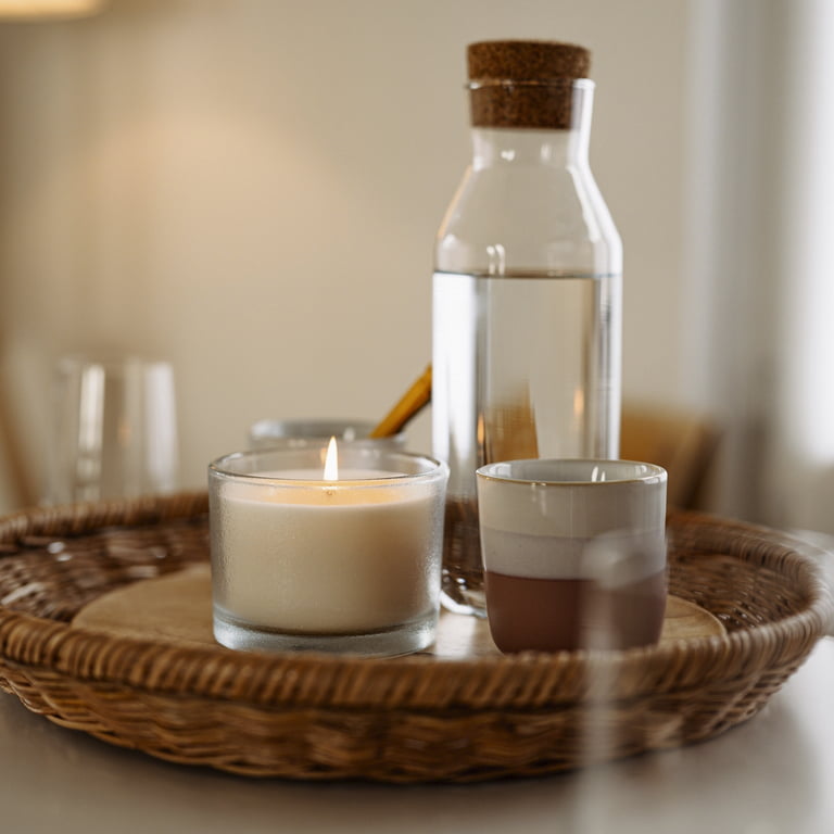 Foto des Praxisraums – Ein Tablett mit Kerze, Wasserkaraffe und Gläser auf einem Tisch